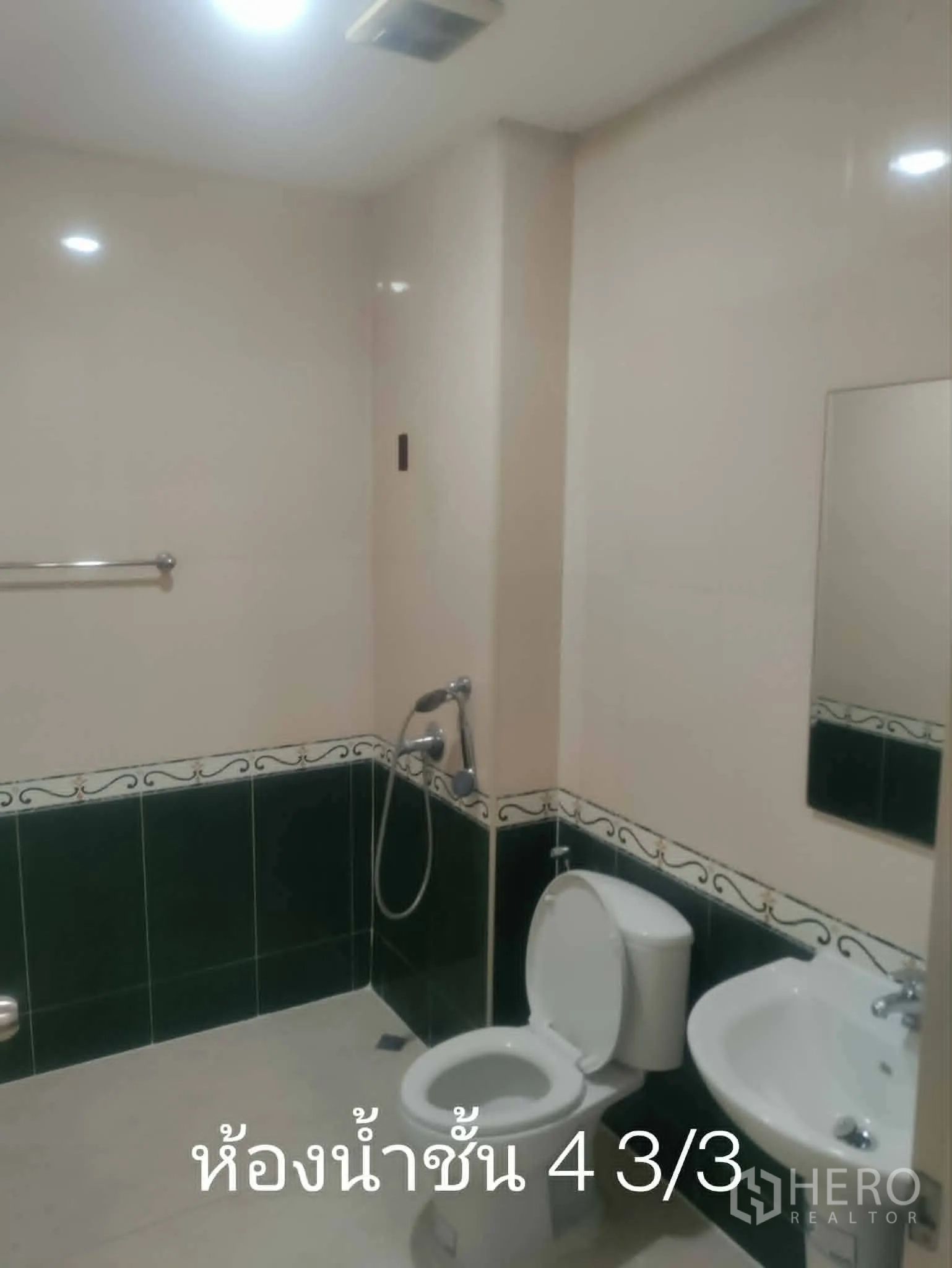 Home Office for rent in Lat Phrao, Bangkok - Tiled bathroom with toilet, sink, handheld shower, and mirror.