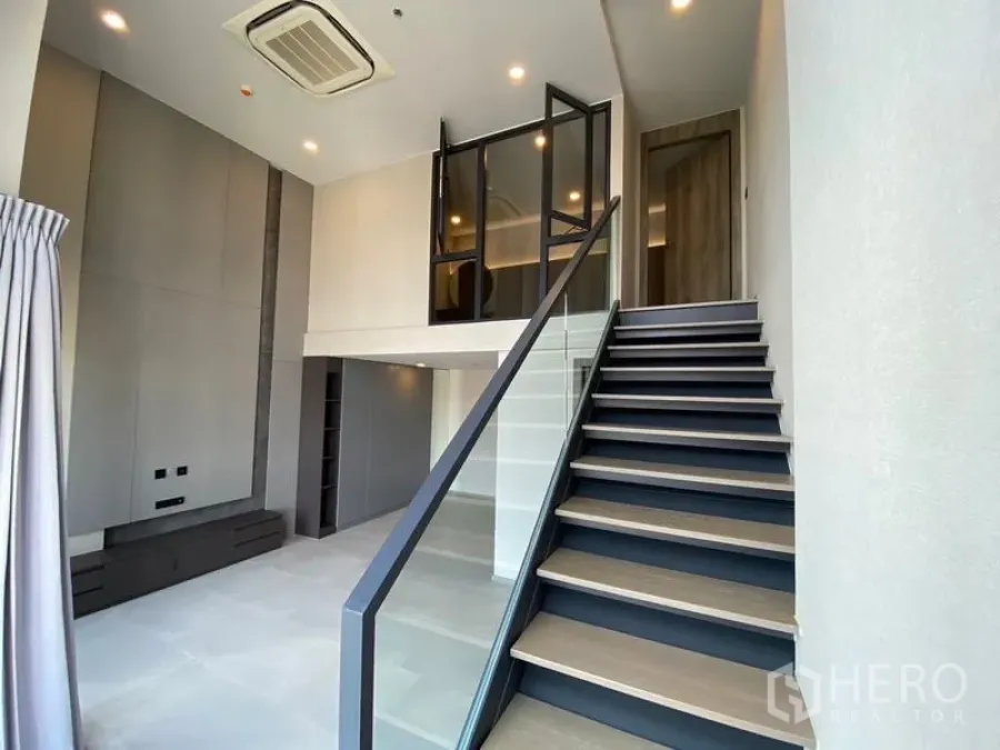 คอนโด ขายในPathum Wan, Bangkok - บันไดราวกระจกขึ้นสู่ชั้นลอยในห้องสไตล์ลอฟต์