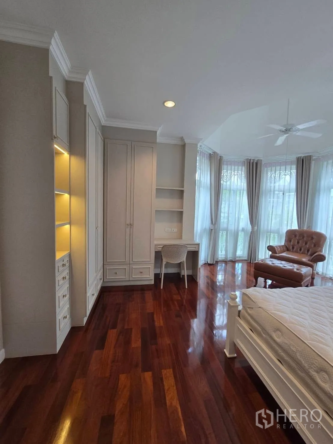 Detached House for rent in Bang Na, Bangkok - Bedroom with bay windows, built-in shelves, desk, and armchair.