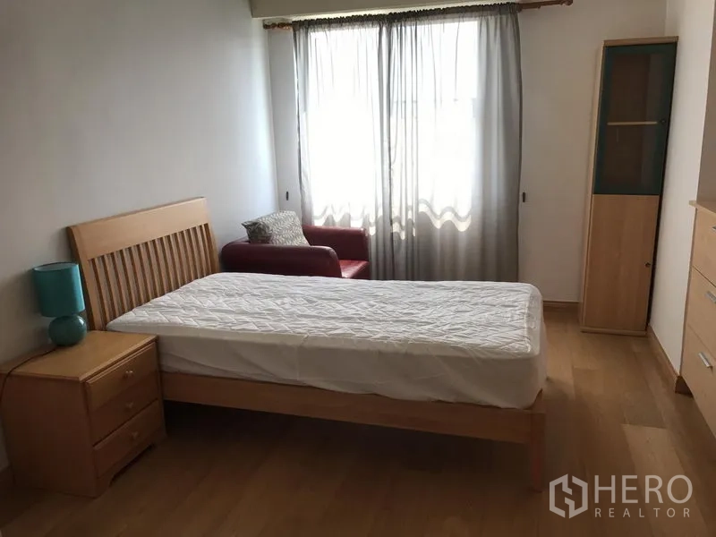 Condominium for rent in Watthana, Bangkok - Spacious bedroom with single bed, sofa by the window and storage cabinet.