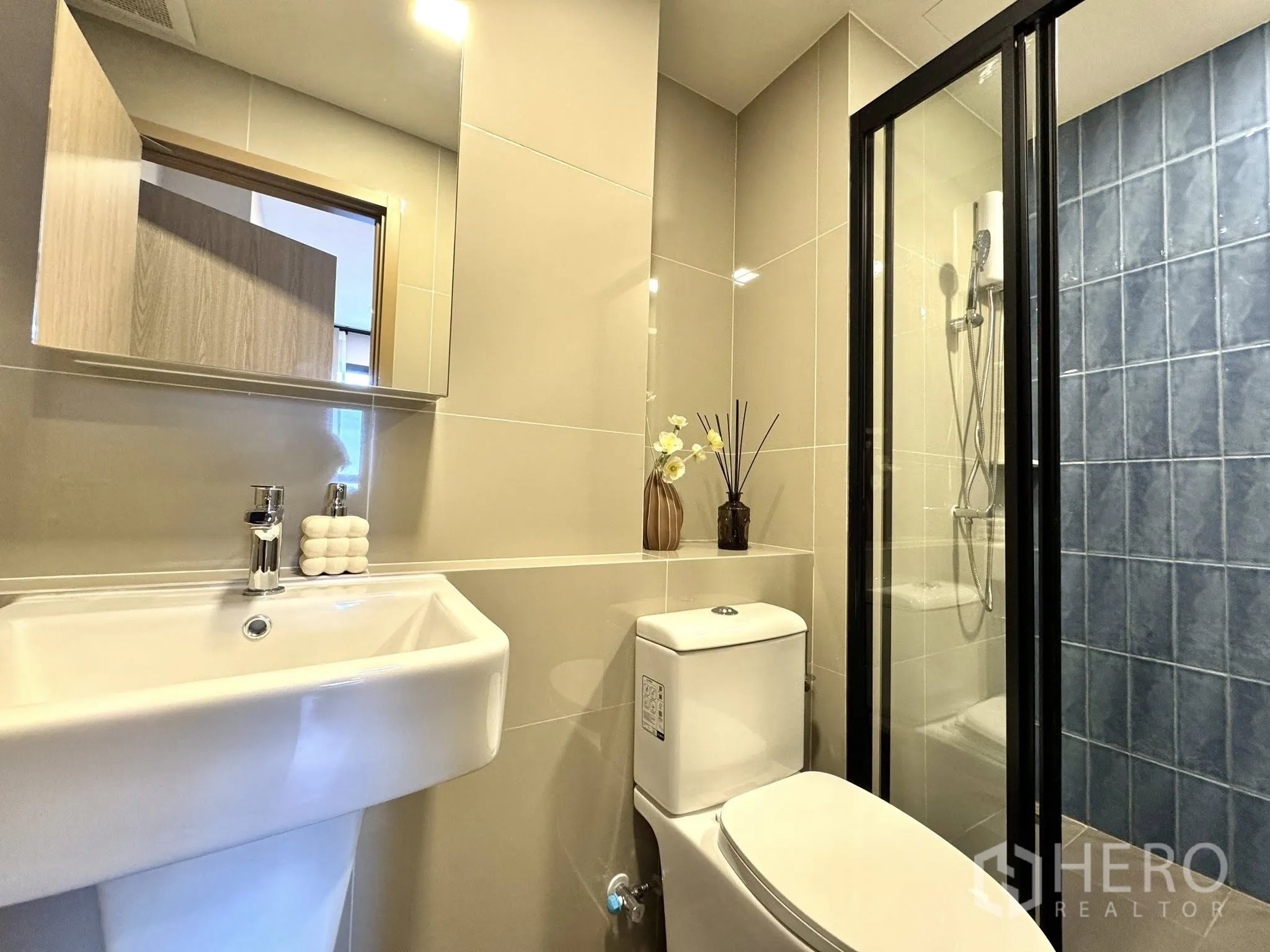 公寓 for rent in Watthana, Bangkok - 浴室带玻璃淋浴间、蓝色瓷砖点缀以及盥洗台。