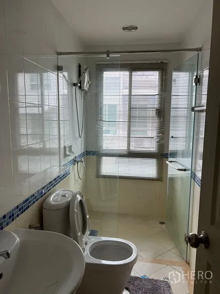 ทาวน์เฮาส์ ให้เช่าในSaphan Sung, Bangkok - ห้องน้ำอีกห้องพร้อมฉากกั้นอาบน้ำกระจก หน้าต่าง และสุขภัณฑ์สีขาว