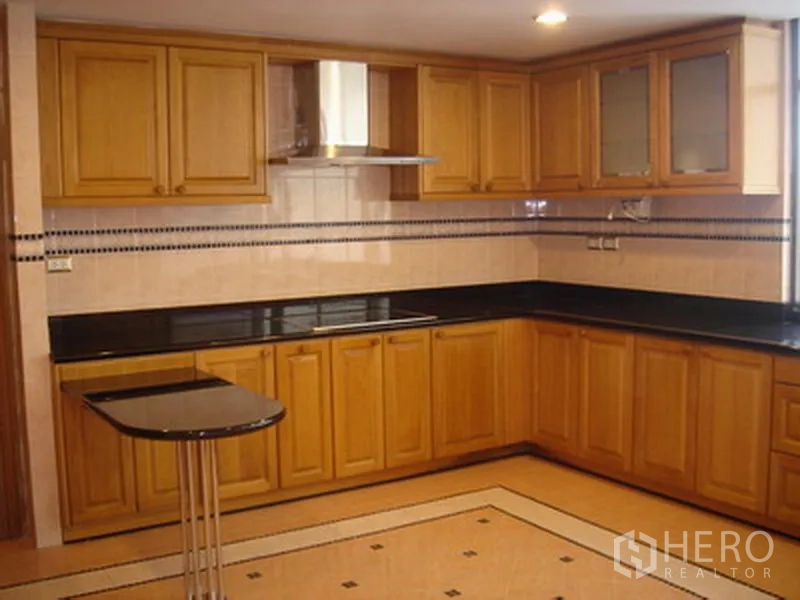 อพาร์ทเมนท์ ให้เช่าในKhlong Toei, Bangkok - ครัวรูปตัว U ตู้ไม้ เคาน์เตอร์ดำ เตาและเครื่องดูดควัน