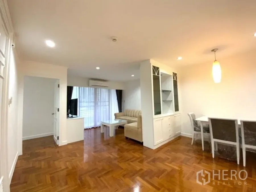 คอนโด ให้เช่าในWatthana, Bangkok - ห้องนั่งเล่นและทานอาหารแบบเปิดโล่ง พื้นปาร์เกต์ โซฟาสีเบจ ชั้นวางทีวี ตู้บิลท์อิน และประตูกระจกสู่ระเบียง