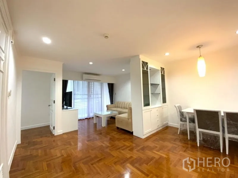 คอนโด ให้เช่าในWatthana, Bangkok - ห้องนั่งเล่นและทานอาหารแบบเปิดโล่ง พื้นปาร์เกต์ โซฟาสีเบจ ชั้นวางทีวี ตู้บิลท์อิน และประตูกระจกสู่ระเบียง