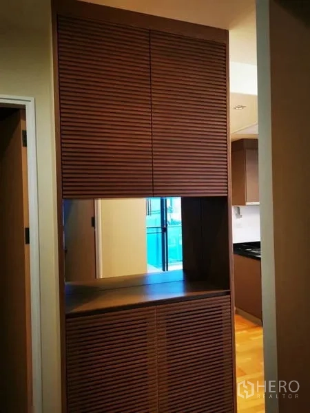 公寓 出售在Khlong Toei, Bangkok - 走廊处的木质百叶柜，可见厨房。