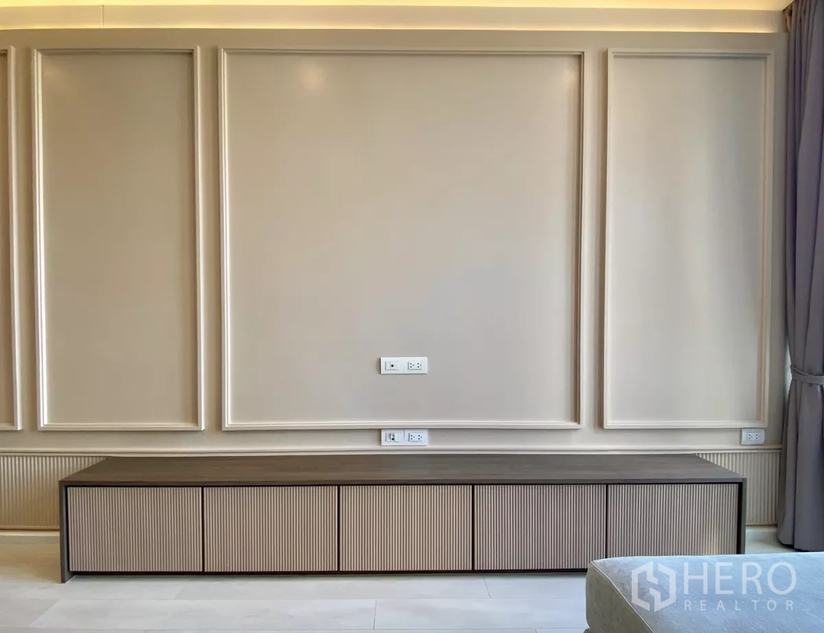 คอนโด ขายในPathum Wan, Bangkok - ผนังทีวีตกแต่งบัว พร้อมตู้เก็บของยาวและช่องปลั๊กไฟ