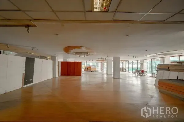 零售空间 出租在Watthana, Bangkok - 大型零售楼层，圆形吊顶装饰、木质地面与环幕玻璃。