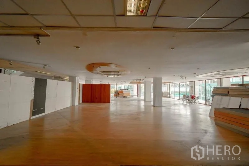 零售空间 出租在Watthana, Bangkok - 大型零售楼层，圆形吊顶装饰、木质地面与环幕玻璃。