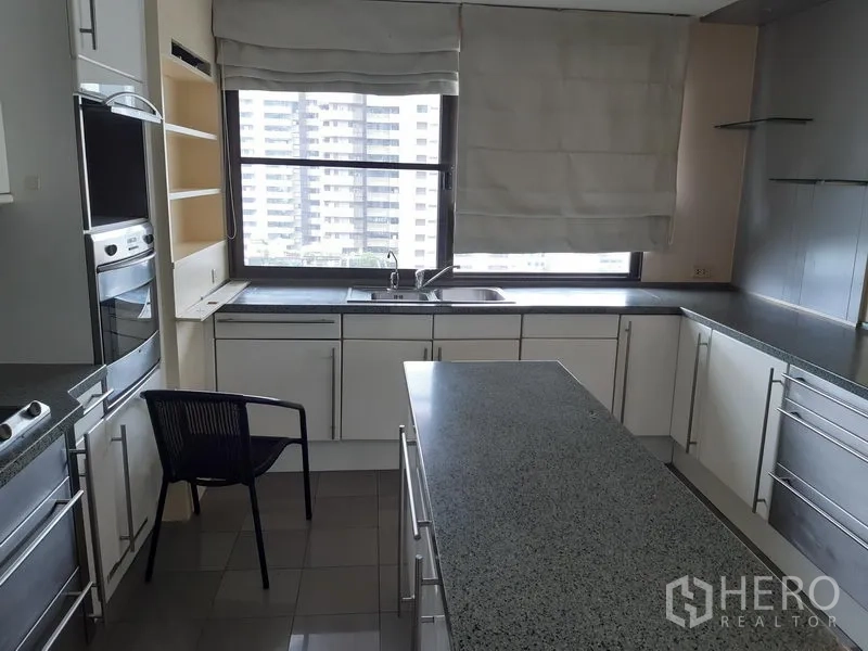 คอนโด ให้เช่าในKhlong Toei, Bangkok - ห้องครัวรูปตัว U สว่าง ไอส์แลนด์ท็อปหินแกรนิต ตู้สีขาว และหน้าต่างบานใหญ่เห็นวิวเมือง เขตคลองเตย กรุงเทพฯ