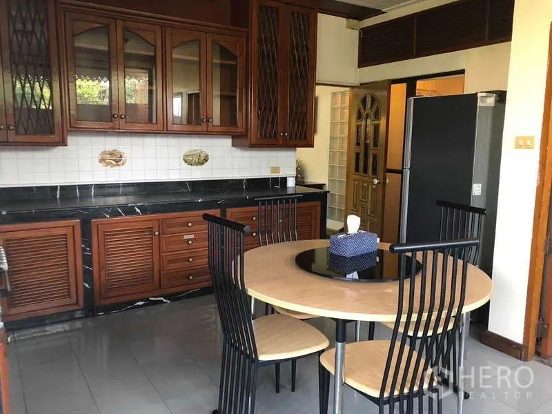 ทาวน์เฮาส์ ให้เช่าในKhlong Toei, Bangkok - ครัวปิดตู้ไม้ เคาน์เตอร์หินสีดำ พร้อมโต๊ะอาหารทรงกลม