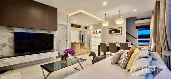 Detached House for rent in Samut Prakan - Contemporary living room with marble TV wall, sofa and dining area under pendant lights.