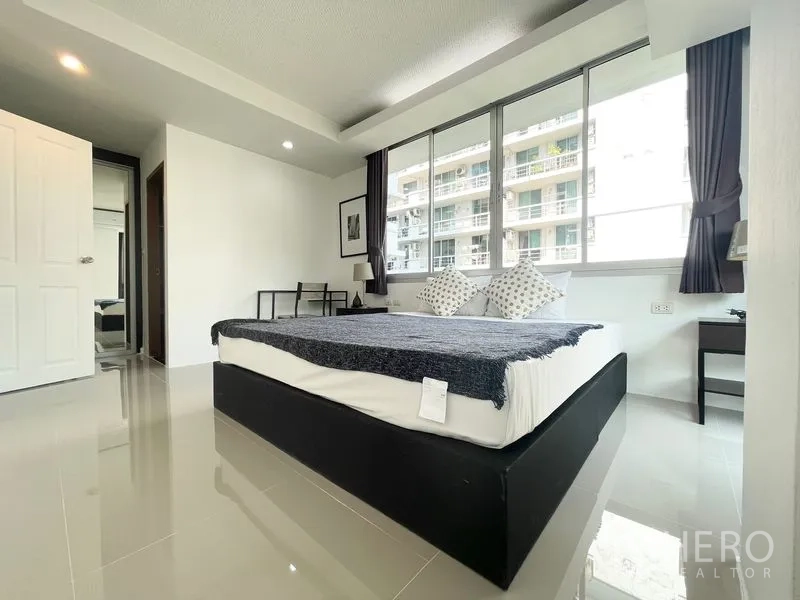 คอนโด for rent in Khlong Toei, Bangkok - ห้องนอนกว้าง หน้าต่างยาว พร้อมโต๊ะข้าง มองอาคารใกล้เคียง