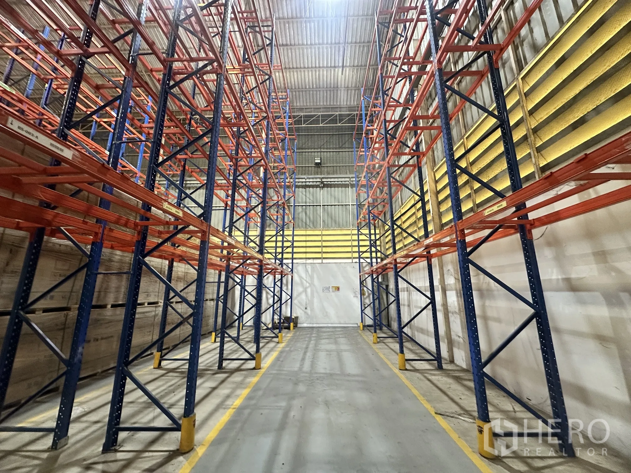 Warehouse for rent in Lat Krabang, Bangkok - Empty aisle between pallet racks with marked lanes for forklifts.