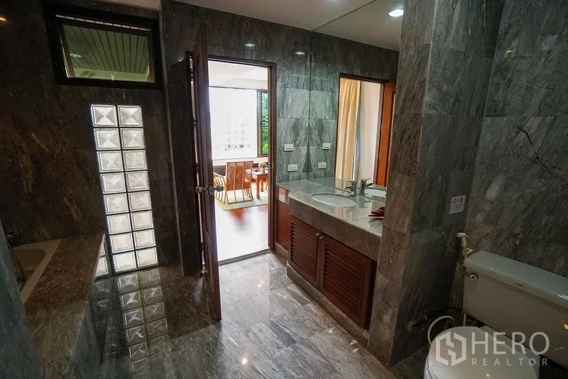 อพาร์ทเมนท์ ให้เช่าในWatthana, Bangkok - ห้องน้ำหินอ่อนพร้อมอ่างล้างหน้าคู่ อ่างอาบน้ำ และผนังก่อบล็อกแก้ว