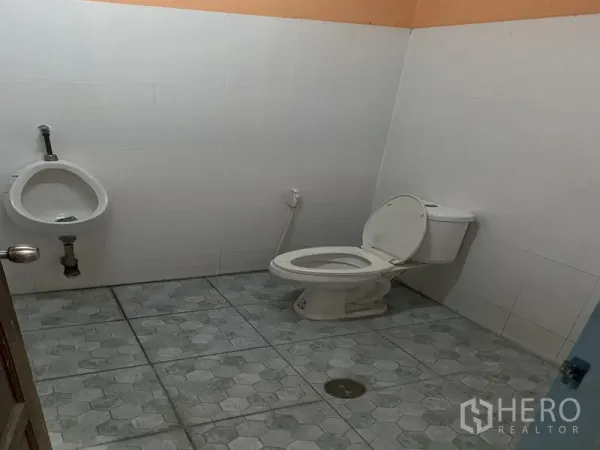 货栈 出租在Bueng Kum, Bangkok - 仓库内卫生间，配有坐便器和小便池，瓷砖地面，整洁明亮。