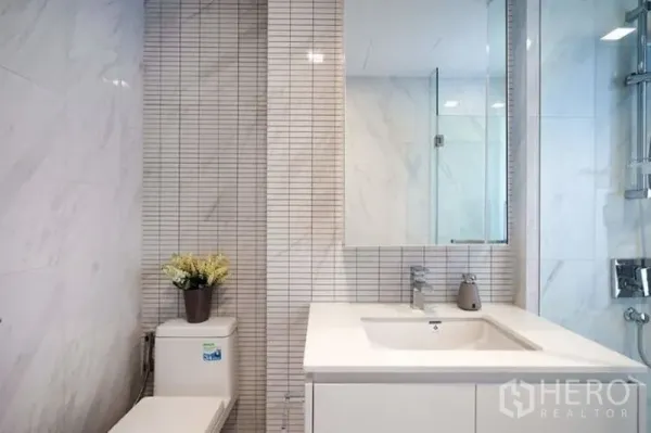 คอนโด ให้เช่าในWatthana, Bangkok - ห้องน้ำที่สองพร้อมอ่างล้างหน้ามีตู้กระจก โถสุขภัณฑ์ และตู้ฝักบัว ผนังลายหินอ่อน