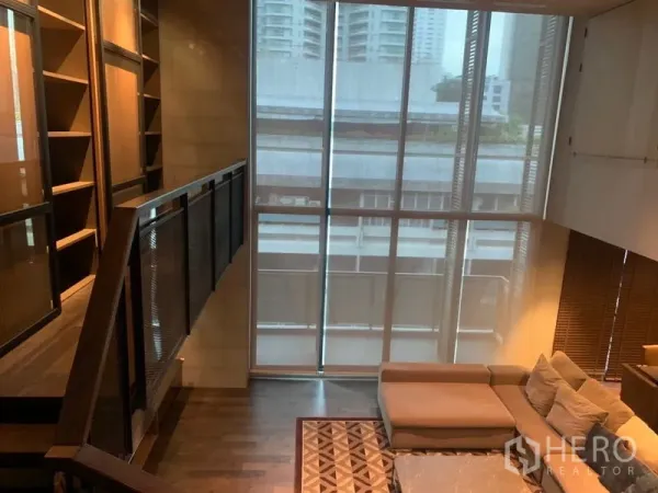 คอนโด ให้เช่าในWatthana, Bangkok - บันไดและหน้าต่างกระจกสูงจรดเพดาน ข้างโซฟา L‑shape