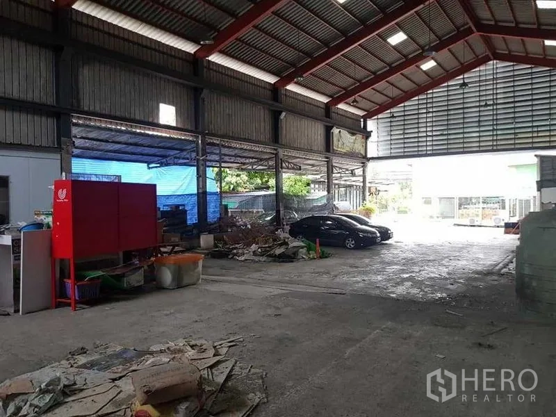 คลังสินค้า ให้เช่าในThung Khru, Bangkok - มุมทำงานในโกดัง มีตู้เครื่องสีแดง พื้นที่เก็บของ และชายคาด้านข้าง