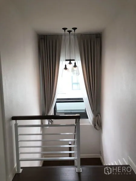Detached House for rent or sale in Bang Kapi, Bangkok - Stair landing with pendant lights, window and full-length curtains.