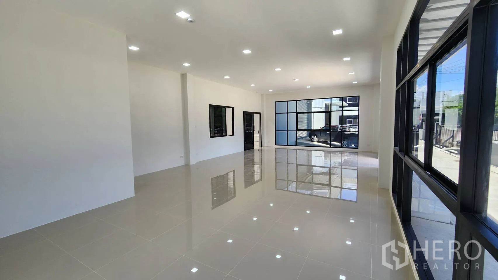 Factory for rent or sale in Bang Bo, Samut Prakan - Ground‑floor office with full‑height glazing opening to the front apron and parking.