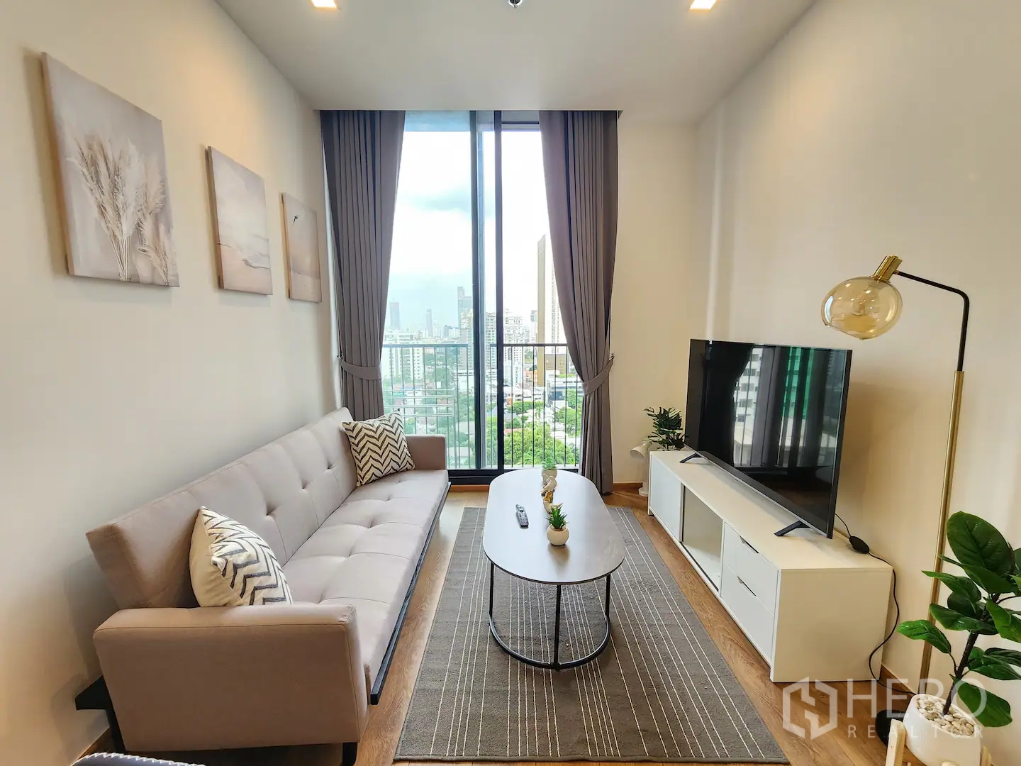 คอนโด for rent in Watthana, Bangkok - ห้องนั่งเล่นสว่าง โซฟา ตู้วางทีวี และหน้าต่างสูงจรดเพดานเปิดสู่ระเบียงวิวเมือง