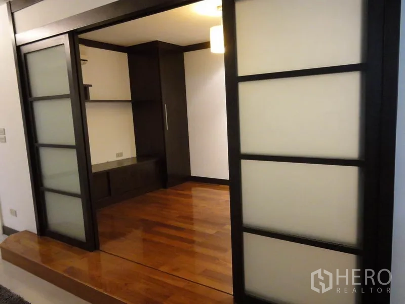 คอนโด ให้เช่าในWatthana, Bangkok - ห้องพร้อมประตูบานเลื่อนกรอบสีดำ พื้นไม้ และชั้นวาง