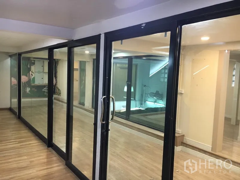 零售空间 出租在Watthana, Bangkok - 黑框滑动玻璃门分隔可灵活布局的零售区域。