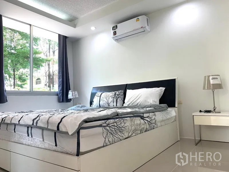 คอนโด ให้เช่าหรือขายในKhlong Toei, Bangkok - ห้องนอนสว่างด้วยหน้าต่างบานใหญ่ มีผ้าม่าน แอร์ และโต๊ะข้างเตียง