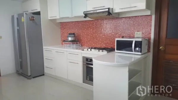 คอนโด ให้เช่าในKhlong Toei, Bangkok - ครัวโทนขาวสมัยใหม่ มีเตาแก๊ส เตาอบ และผนังกระเบื้องโมเสคสีแดง