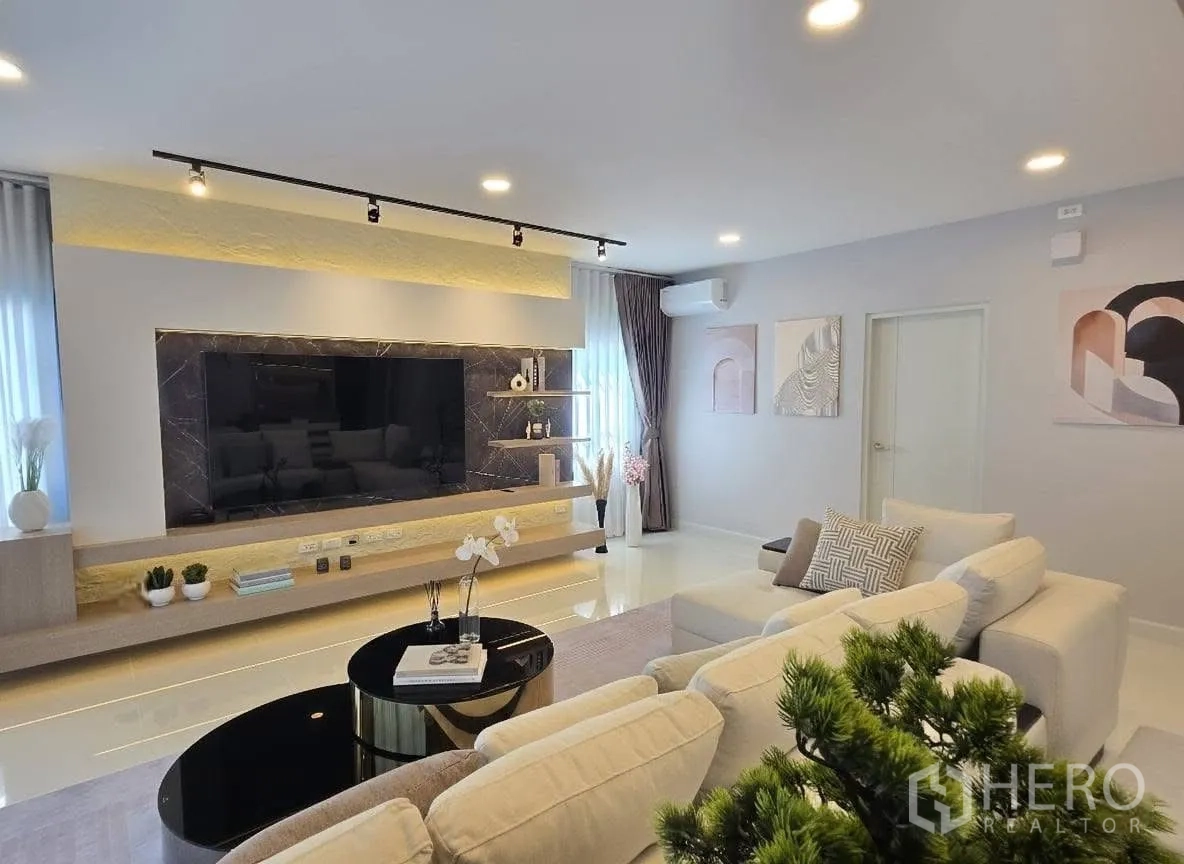 Detached House for rent or sale in Bang Phli, Samut Prakan - Close‑up of extra‑wide TV wall with marble surround and floating shelf in the living room.