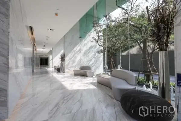 Condominium for rent or sale in Watthana, Bangkok - Bright marble lobby with contemporary seating, floor‑to‑ceiling windows and garden views.