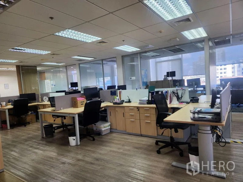 办公空间 出租 - 宽敞楼层布置，多排工位与天花板荧光灯。
