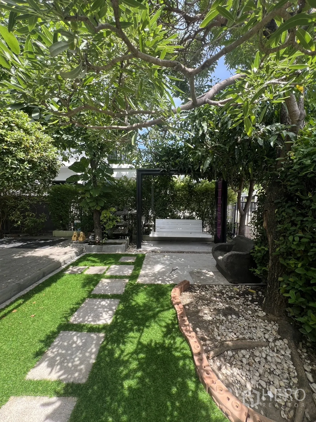 Detached House for rent in Bang Phli, Samut Prakan - Shaded front garden with stepping-stone path, trees and a seating area.