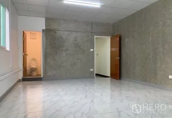 Home Office for rent in Sathon, Bangkok - Spacious room with a gray feature wall and an ensuite bathroom.