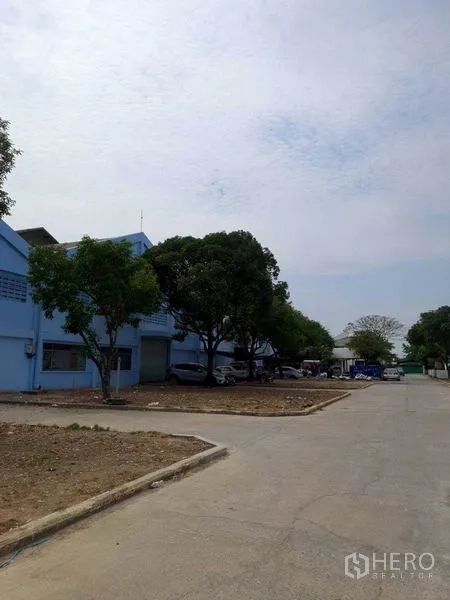 货栈 出租在Nakhon Pathom - 仓库侧面与多栋连排，沿混凝土路面留有宽敞退距。
