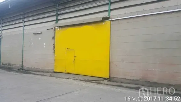 โรงงาน ให้เช่าในBang Phli, Samut Prakan - ด้านหน้าโรงงาน ประตูบานเลื่อนโลหะสีเหลืองขนาดใหญ่ติดถนนคอนกรีต