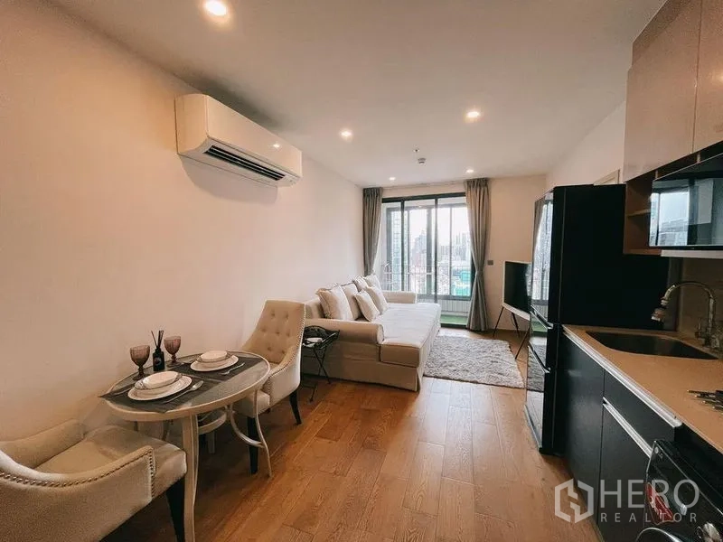 คอนโด ให้เช่าในRatchathewi, Bangkok - โซนนั่งเล่นและรับประทานอาหารพร้อมโซฟา ชุดโต๊ะเล็ก และประตูกระจกบานเลื่อนสู่ระเบียง