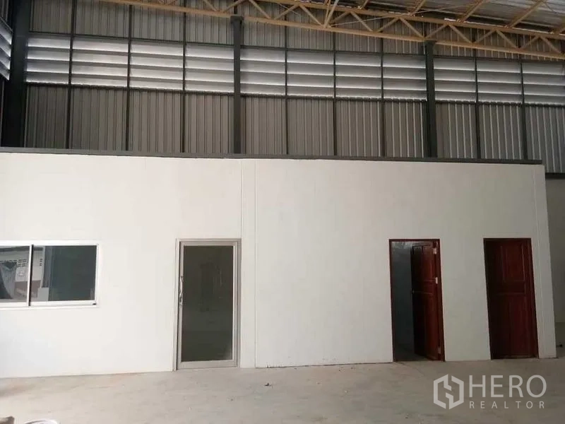 Warehouse for rent in Suan Luang, Bangkok - Interior warehouse office block with doors and window beneath ventilated steel cladding and truss roof.