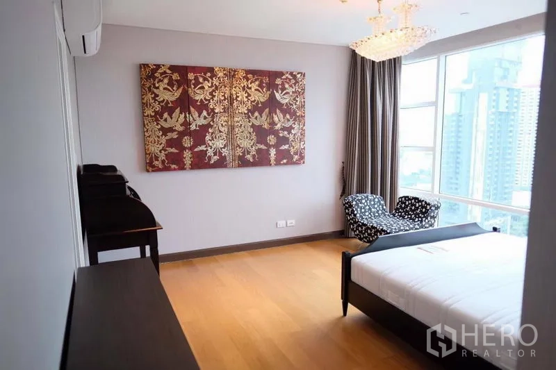 Condominium for rent in Watthana, Bangkok - Spacious master bedroom with chandelier lighting, floor-to-ceiling windows and a seating nook.