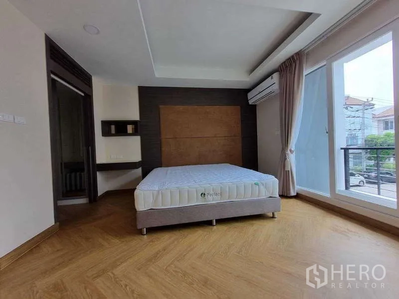 ทาวน์เฮาส์ ให้เช่าในWang Thonglang, Bangkok - มาสเตอร์เบดรูมกว้างมีประตูระเบียง ผนังตกแต่ง และพื้นลายก้างปลา