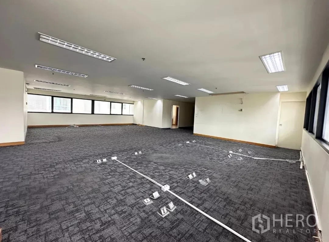 สำนักงาน ให้เช่าในBang Rak, Bangkok - พื้นที่ทำงานโอเพ่นพร้อมรางสายไฟที่พื้นและหน้าต่างกรอบอลูมิเนียมสีดำ