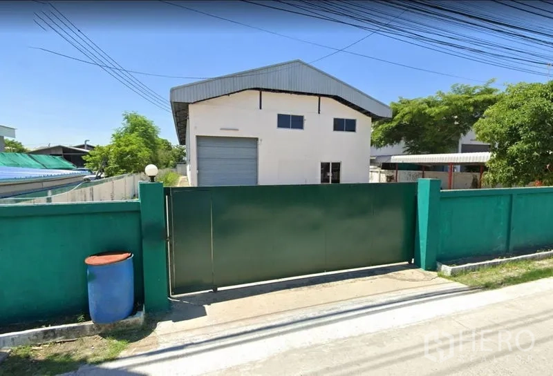 Factory for rent or sale in Bang Phli, Samut Prakan - Street-side view of the factory behind a secure green gate and perimeter wall.