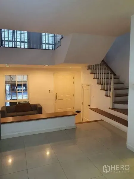 联排别墅 出售在Bang Kapi, Bangkok - 开放式客厅，白色墙面、下沉式空间与楼梯。