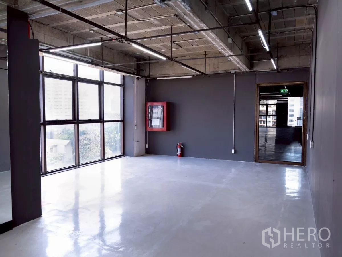Office Space for rent - Smaller office area with large window, fire hose cabinet and extinguisher.