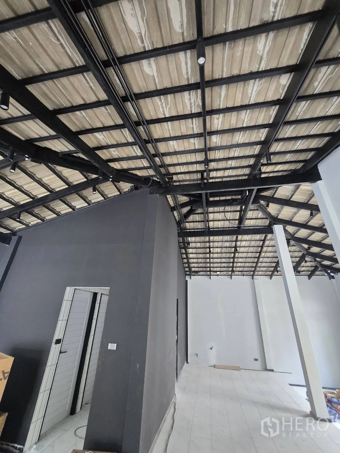 โฮมออฟฟิศ for rent in Phra Khanong, Bangkok - โครงเหล็กหลังคาพร้อมทางเดินและผนังโทนเข้มภายในอาคาร