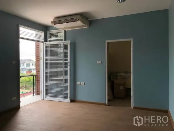 独立式住宅 出售在Bang Khen, Bangkok - 二楼卧室，木地板，空调，玻璃门通阳台，并有套卫入口。