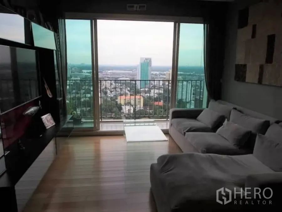 คอนโด ให้เช่าในKhlong Toei, Bangkok - ห้องนั่งเล่นชั้นสูง กระจกเต็มบานพร้อมระเบียงและวิวสกายไลน์กรุงเทพฯ กว้างไกล