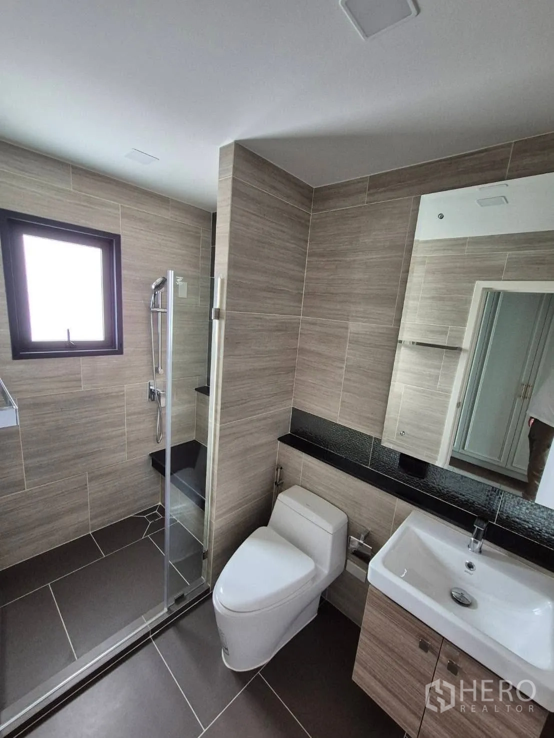 บ้าน ขายในBang Kruai, Nonthaburi - ห้องน้ำสไตล์โมเดิร์น พร้อมตู้กระจกอาบน้ำ อ่างล้างหน้า และโถสุขภัณฑ์ โทนลายไม้