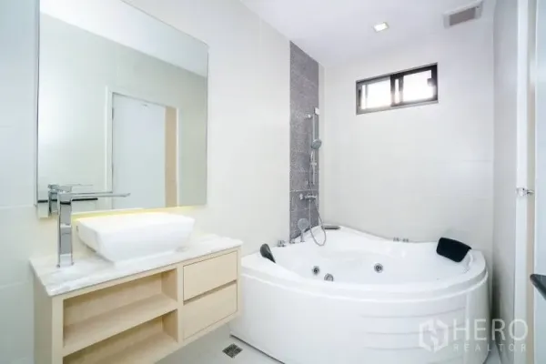 บ้าน ให้เช่าหรือขายในLat Krabang, Bangkok - ห้องน้ำโทนขาวมีอ่างจากุซซี่มุมห้อง ฝักบัว และเคาน์เตอร์อ่างล้างหน้า